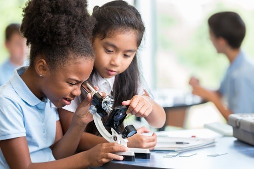 Two students with a microscope